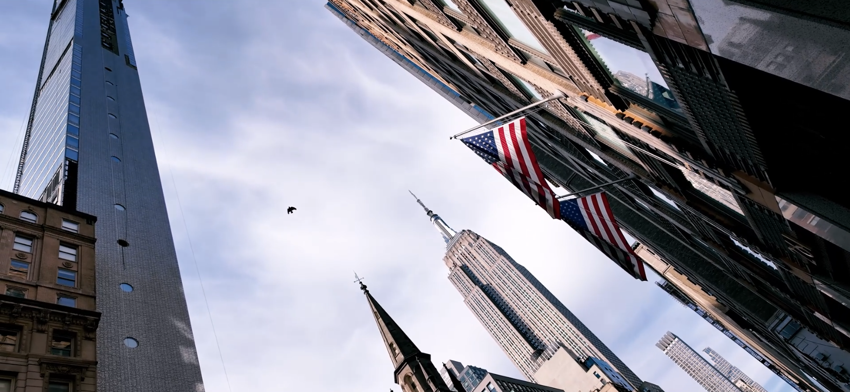 Gratte-ciel de New York et drapeaux américains, contre-plongée vers l'Empire State Building